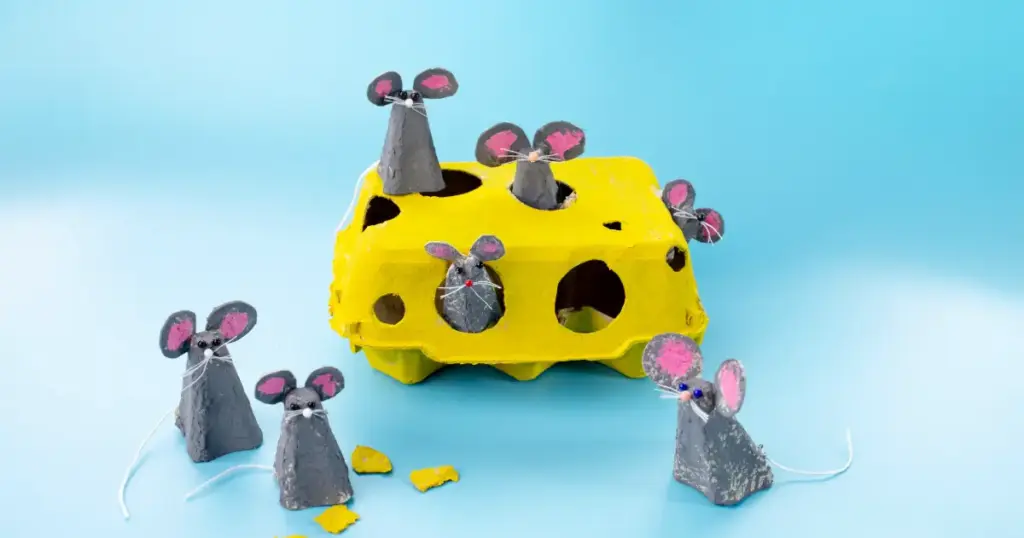 Gelb bemalter Eierkarton als Käse mit kleinen grauen Mäusen – witzige Bastelidee für Kinder aus recyceltem Material
