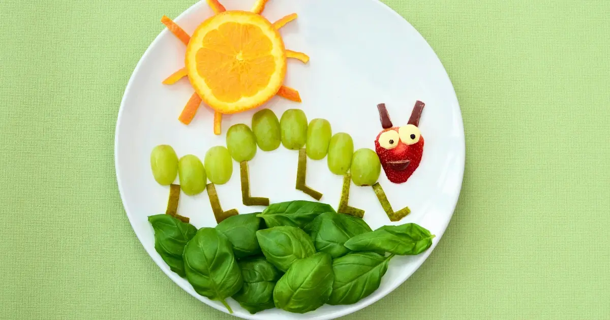 Bunte Obstplatte, dekoriert mit fröhlichen Motiven, gesundes Highlight beim Osterfrühstück.