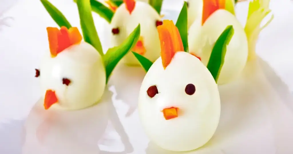Hartgekochte Eier, dekoriert als kleine Küken, perfekte Fingerfood-Idee für den Osterbrunch.