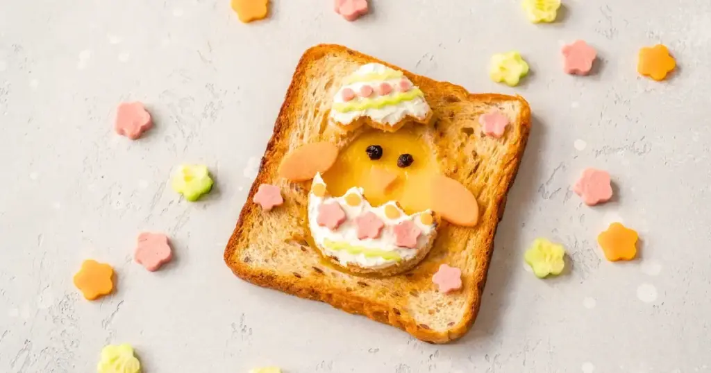 Sandwiches ausgestochen in Form von Osterküken, belegt mit frischen Zutaten, perfekt für Kinder.